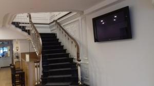 a staircase with a flat screen tv on the wall at Hotel Paulista in Porto
