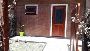a brick house with a door and a flower pot at Santa Teresita Sobre El Monte in Santa Teresita