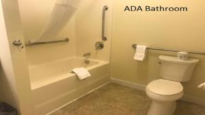 a bathroom with a toilet and a tub and a sink at Affordable Suites - Fayetteville/Fort Bragg in Fayetteville +15 photos
