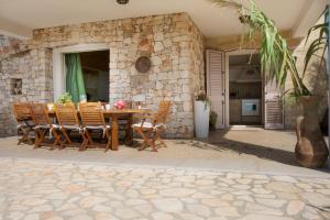 a stone house with a wooden table and chairs at Le Gioie - Villa Macchia Mediterranea - Splendida villa vista mare immersa nel verde in Torre Pali  +111 photos