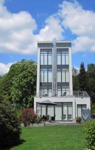 un gran edificio con ventanas de cristal en el césped en Ferienhaus Struckmann am Steinhuder Meer, en Neustadt am Rübenberge