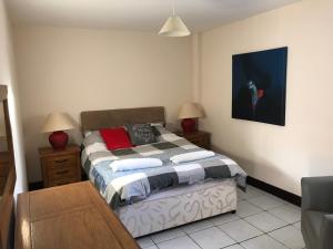 a bedroom with a bed with two lamps on it at Sedbury Farm Cottages in Chepstow