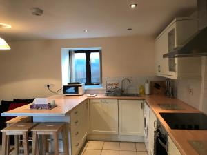 a kitchen with white cabinets and a counter top at Sedbury Farm Cottages in Chepstow