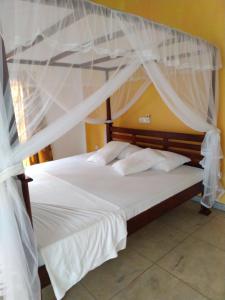 1 dormitorio con 2 camas con mosquiteras en Kith Fiesta Villa, en Hikkaduwa