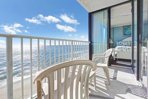 a bedroom with a balcony with a bed and the ocean at Sands Beach Club Resort in Myrtle Beach +5 photos