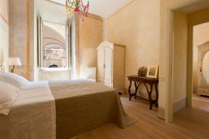 1 dormitorio con cama, mesa y ventana en Appartamento Signoria en Florence
