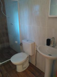 a bathroom with a toilet and a sink at Casa Costa Azul - praça da Baleia in Rio das Ostras +16 photos