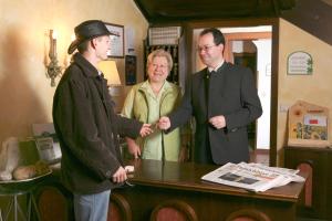 Zwei Männer und eine Frau stehen um einen Tisch herum in der Unterkunft Hotel Grünes Türl in Bad Schallerbach