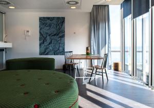 ein Wohnzimmer mit einem Tisch und Stühlen sowie einem großen Fenster in der Unterkunft SWEETS - Sluis Haveneiland in Amsterdam
