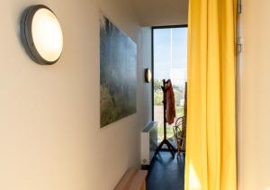 um quarto com uma cortina amarela e um espelho em SWEETS - Sluis Haveneiland em Amsterdã