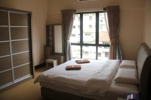 ein Schlafzimmer mit einem Bett und einem großen Fenster in der Unterkunft Kota Kinabalu Marina Homestay in Kota Kinabalu