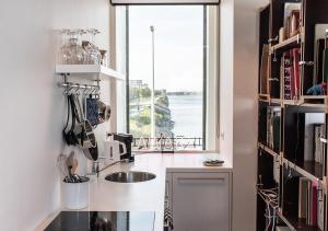 eine Küche mit einem Waschbecken und einem Fenster in der Unterkunft SWEETS - Sluis Haveneiland in Amsterdam