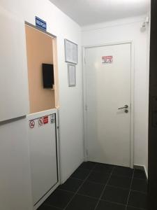 einen Flur mit einer weißen Tür und einem Spiegel in der Unterkunft NN Guest House in Coimbra