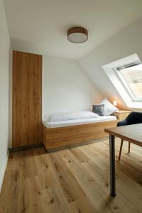 1 dormitorio con 1 cama y suelo de madera en Gasthaus Dörsthof, en Alzenau