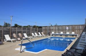 
a pool with a lot of chairs and umbrellas at Seagrass Inn in Old Orchard Beach
