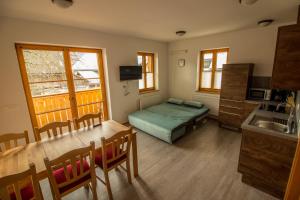 a room with a bed and a table and a kitchen at Apartments & Rooms Pr' Skalovc in Bohinj
