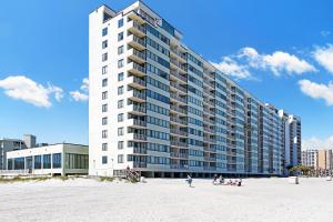 a large building on the beach with people in front of it at Sands Beach Club Resort in Myrtle Beach