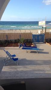 two lounge chairs and a table on the beach at Villa Casa Madre in San Vito lo Capo