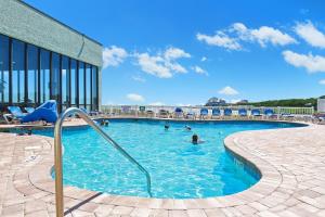 a swimming pool with people in the water at Sands Beach Club Resort in Myrtle Beach