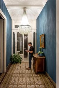 a man standing in a blue hallway with at The Piano Guesthouse - Kwaadham52 in Ghent +17 photos