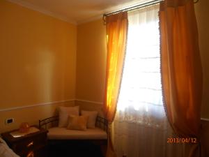 1 dormitorio con ventana, 1 cama y asiento junto a la ventana en Cerasola Bed & Breakfast, en Campello sul Clitunno