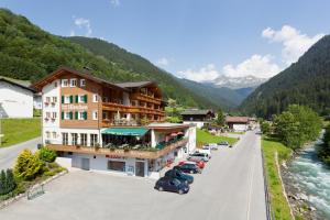 un hotel en las montañas con coches aparcados en la calle en Hotel Hirschen, en Silbertal