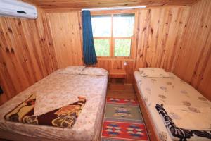 a bedroom with two beds and a window at Olympos Varuna Pansiyon in Olympos