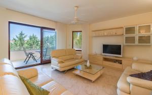 uma sala de estar com um sofá e uma televisão em Apartmani Kažun - App3 em Fažana
