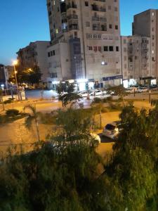 a city at night with cars parked in a parking lot at Appartement Akid Lotfi Oran in Oran