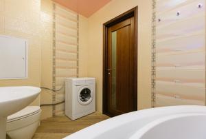 a bathroom with a washing machine next to a toilet at Apartamenty Svetlica Shamshinykh 90/5 studio in Novosibirsk