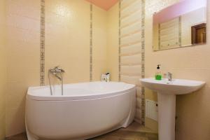 a bathroom with a white tub and a sink at Apartamenty Svetlica Shamshinykh 90/5 studio in Novosibirsk