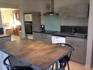 a kitchen with a wooden table and chairs at La roseraie Bonnieux in Bonnieux +19 photos