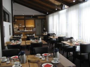 une salle à manger avec des tables et des chaises dans un restaurant dans l'établissement Landhotel Weisses Ross garni, à Bad Brückenau