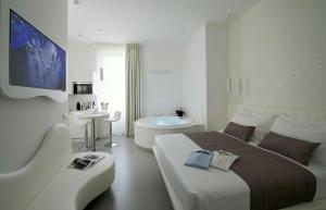 Mia Boutique Hotel في ميلانو: غرفة نوم بسرير كبير وحوض استحمام