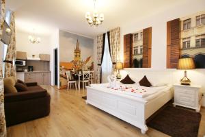 a bedroom with a white bed and a living room at Arhivelor Apartment in Sibiu