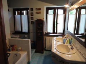 ein Badezimmer mit zwei Waschbecken, einer Badewanne und einer Badewanne in der Unterkunft Villa Arzilla in Amandola