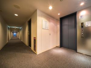 un pasillo de un edificio de oficinas con un pasillo en Super Hotel Takamatsu Tamachi en Takamatsu