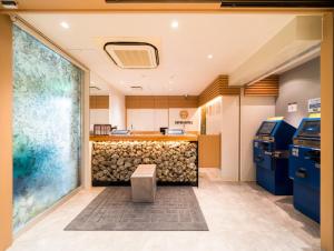 una sala de espera con un mostrador y un banco en Super Hotel Takamatsu Tamachi, en Takamatsu