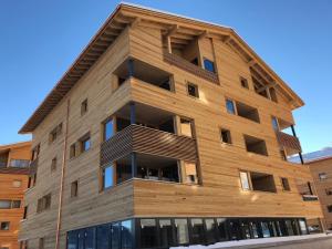 a tall wooden building with a gambrel at Catrina Resort in Disentis
