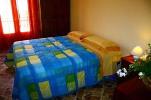 una camera con letto e piumone blu e giallo di Agliastri Apartments a Castellammare del Golfo