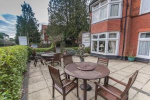 a patio with tables and chairs and a building at Grovefield Manor in Poole
