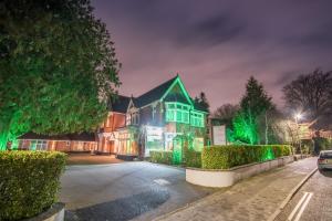 a house with green lights on a street at night at Grovefield Manor in Poole