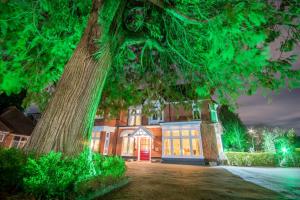 an old house with a tree in front of it at Grovefield Manor in Poole