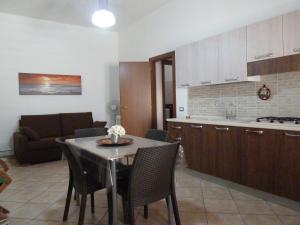 a kitchen and living room with a table and chairs at Sole in San Vito lo Capo
