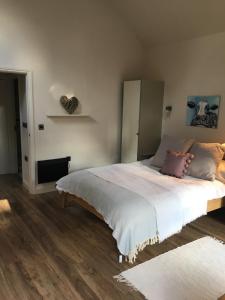 a bedroom with a large bed with white sheets at The coach house in Grimston