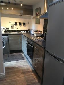 a kitchen with a stainless steel refrigerator and cabinets at The coach house in Grimston