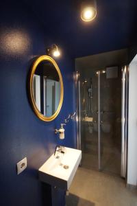 a bathroom with a sink and a mirror and a shower at Seemannsheim Hostel Flensburg in Flensburg