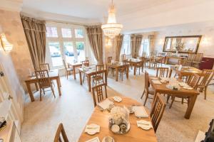 comedor con mesas y sillas de madera en Grovefield Manor, en Poole
