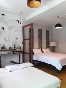 une chambre avec deux lits et un mur avec des dessins dessus dans l'établissement Baan Hotelier Resort, à Trat 76 autres photos