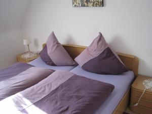 two beds with purple pillows sitting next to each other at Ferienwohnung Weber in Schleiden